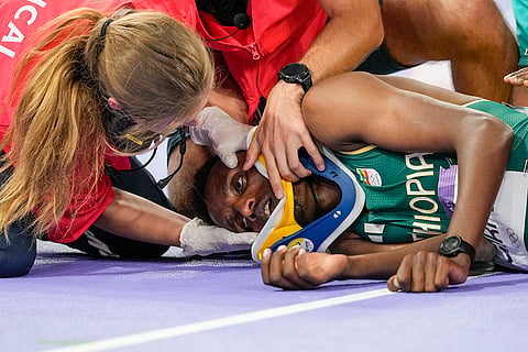 Lamecha Girma, of Ethiopia, is treated on the track after being injured during the men's 3000-meter steeplechase final